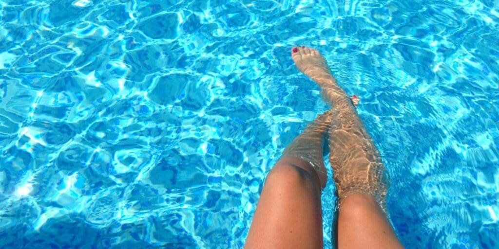 Girl Dipping Feet in Clean Pool Water - Home Pool Maintenance Keeps Pool Ready to Swim