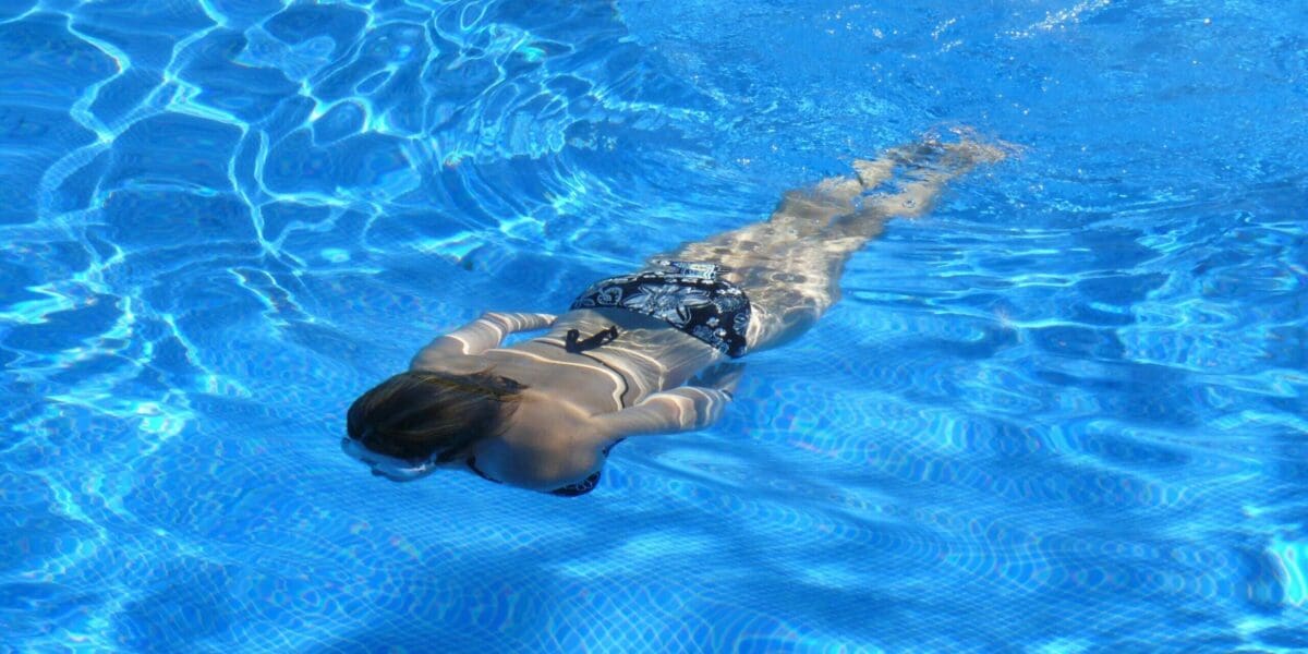 Woman Swimming on the Pool With Clean Clear Pool Water Woman Swimming on the Pool With Clean Clear Pool Water